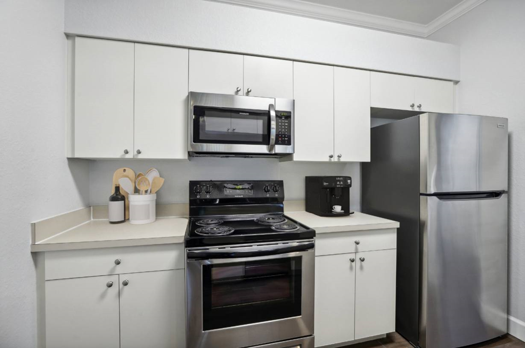 A modern kitchen with stainless steel appliances and white cabinets.